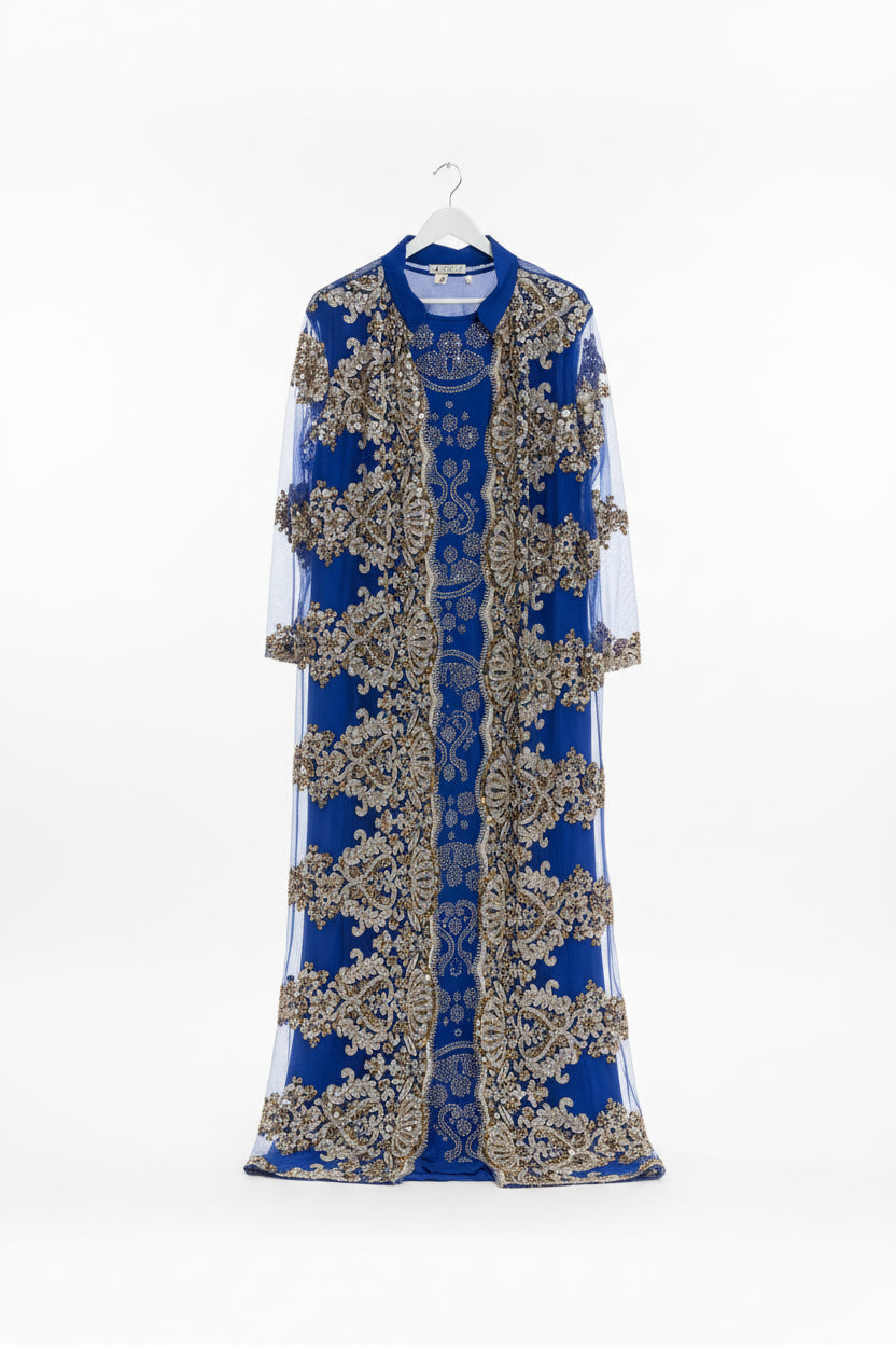 Blue dress with intricate silver embroidery on a colorful background of folded fabric.